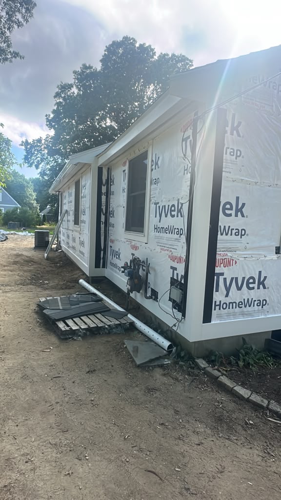 Single story home fully wrapped in house wrap with new trim ready for siding