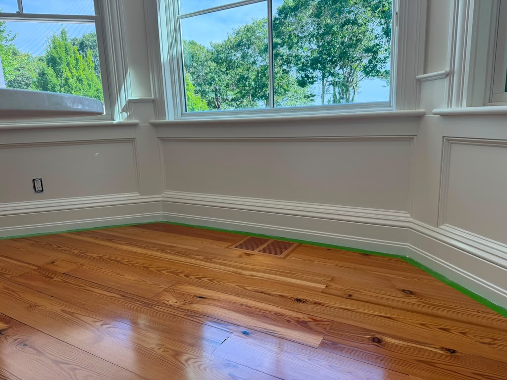 Bay window with custom white wainscoting, casing and refinished pine hardwood flooring