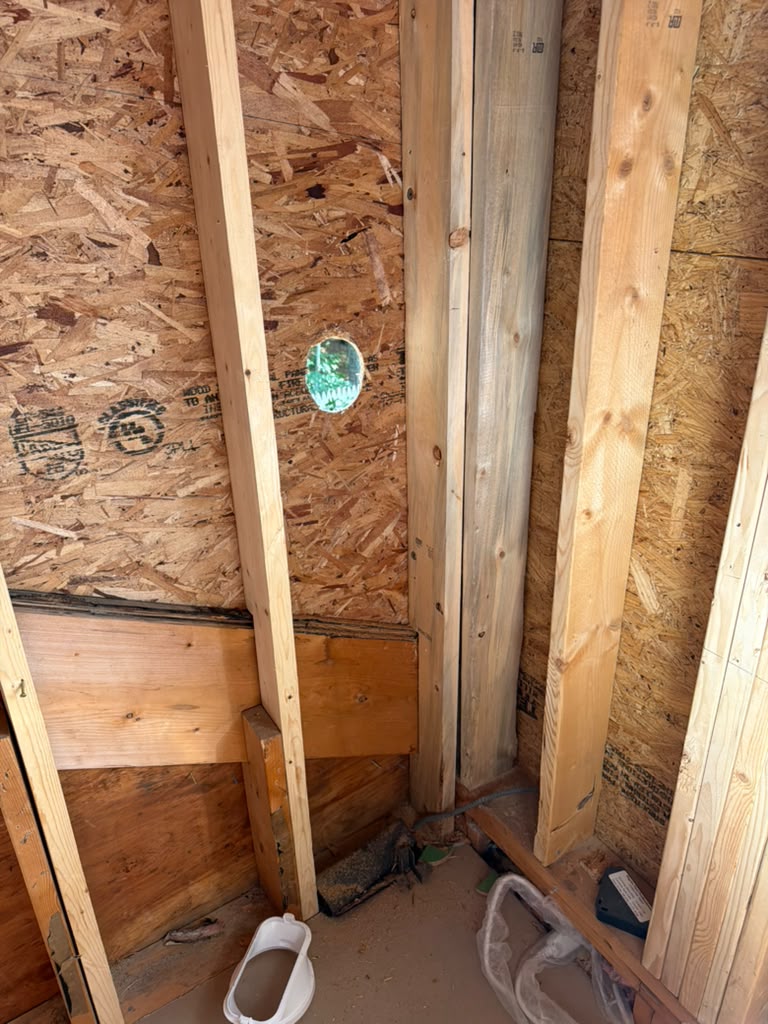 Interior corner framed with new studs and sheathing during a structural remodel